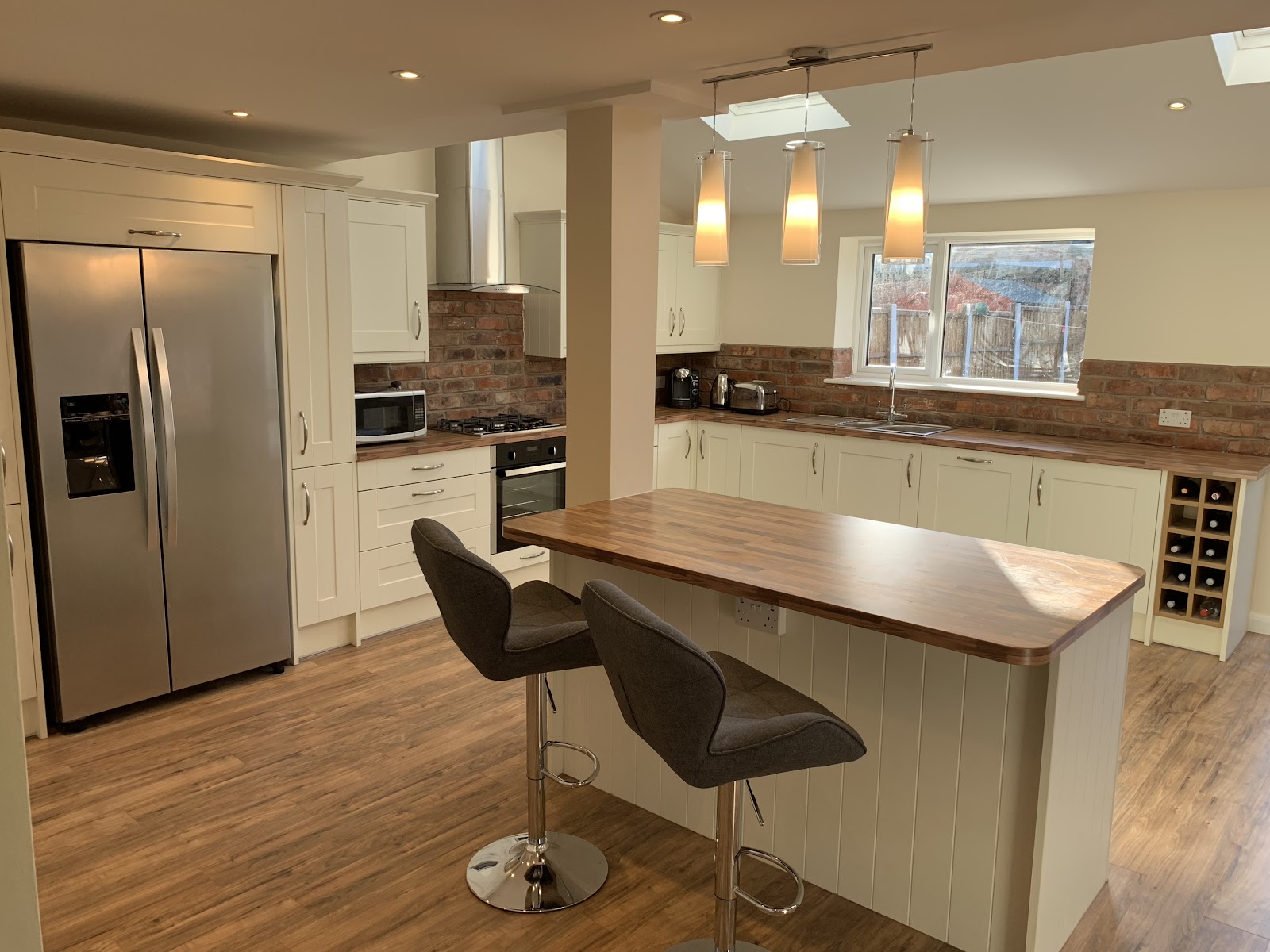 A bright cream shaker kitchen with wood worktops, breakfast bar and skylights — a full home refurbishment by Britannia Building Co in Liverpool