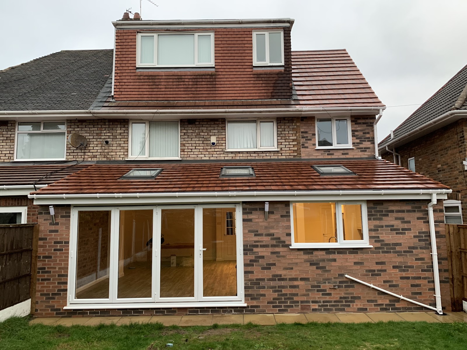 A completed rear extension with a tiled loft dormer and bi-fold doors on a Merseyside home