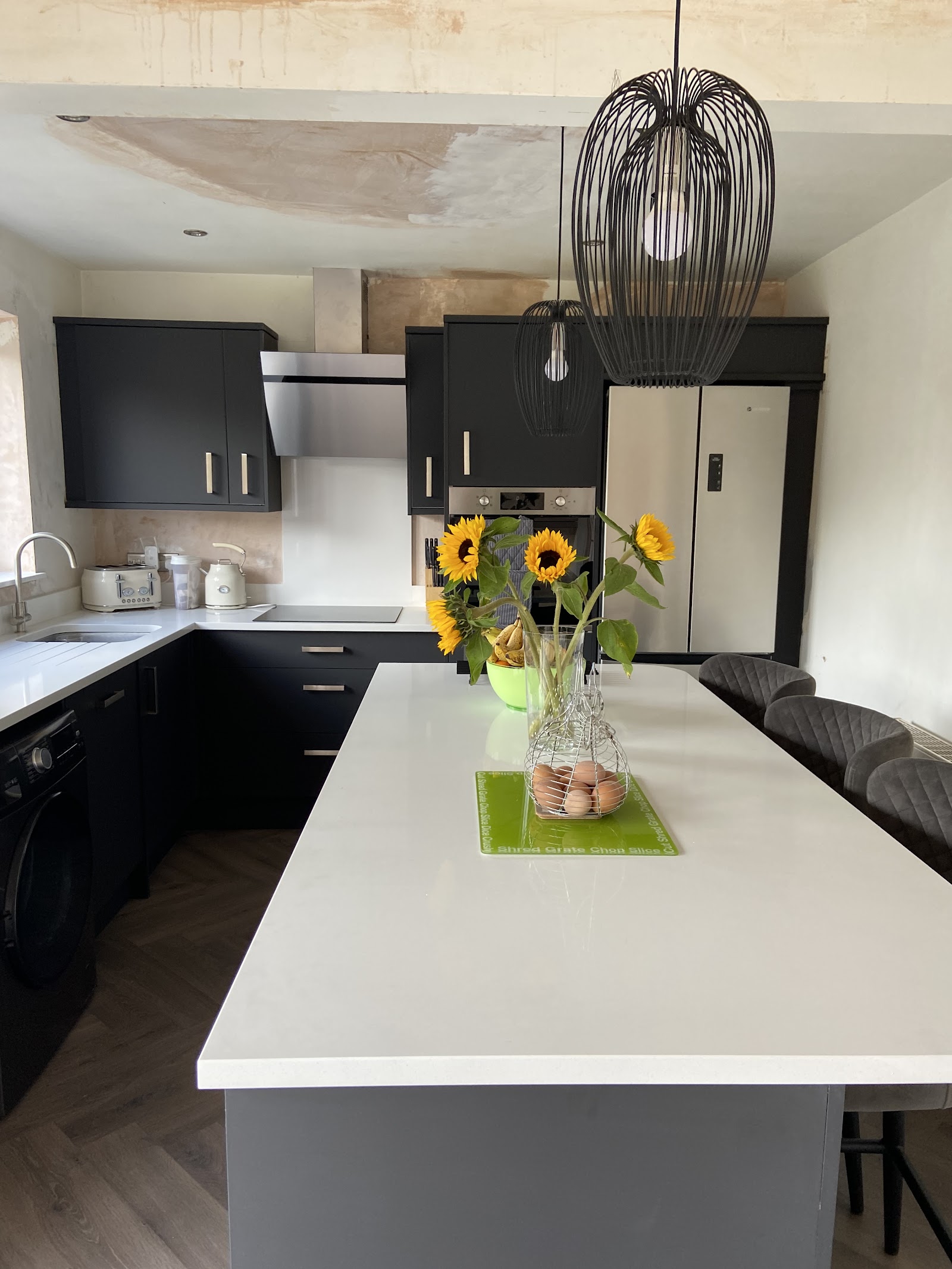 Handleless dark kitchen with a white quartz island and breakfast seating